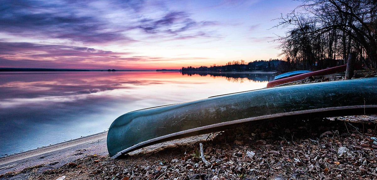 A canoe sitting on the shores of a lake