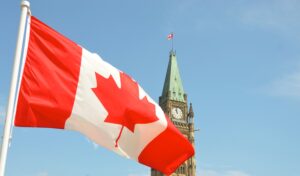 Canadian flag in the foreground of Parliament.