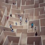 People navigating a large maze in a gallery space.