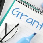 Paper that has “Grants” written on it with blue marker.